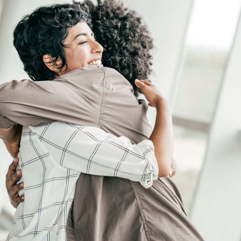 Two people sharing a heartfelt hug after meeting in person for the first time.